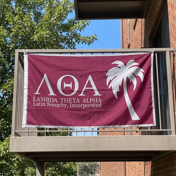 Lambda Theta Alpha Flags and Banners — hanging on an apartment balcony