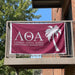 Lambda Theta Alpha Flags and Banners — hanging on an apartment balcony